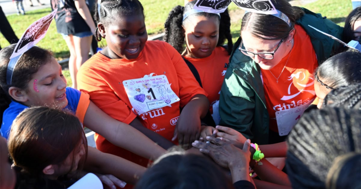 A colorful group of children and adults participating in a community event outdoors.