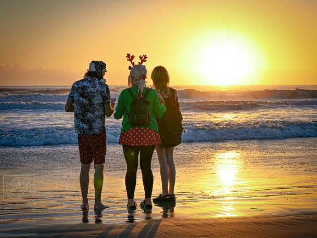 Enjoying sunset at the beach with friends, holiday, winter, festive, reindeer hat, fun, sunset, ocea.