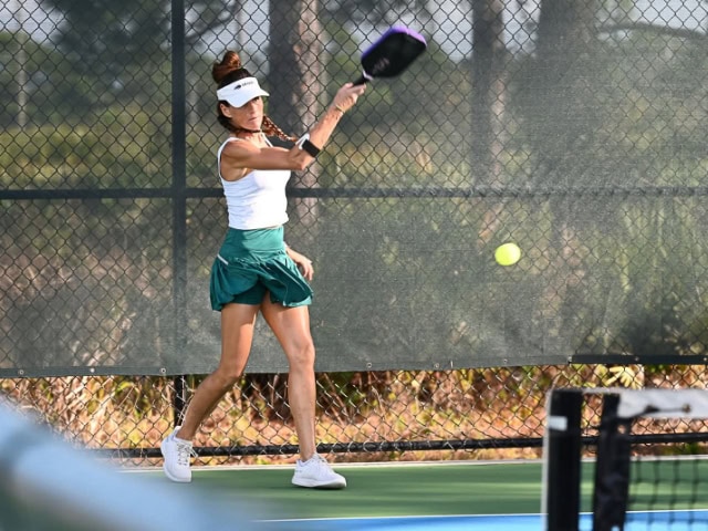 Man with cap hits ball with raquet